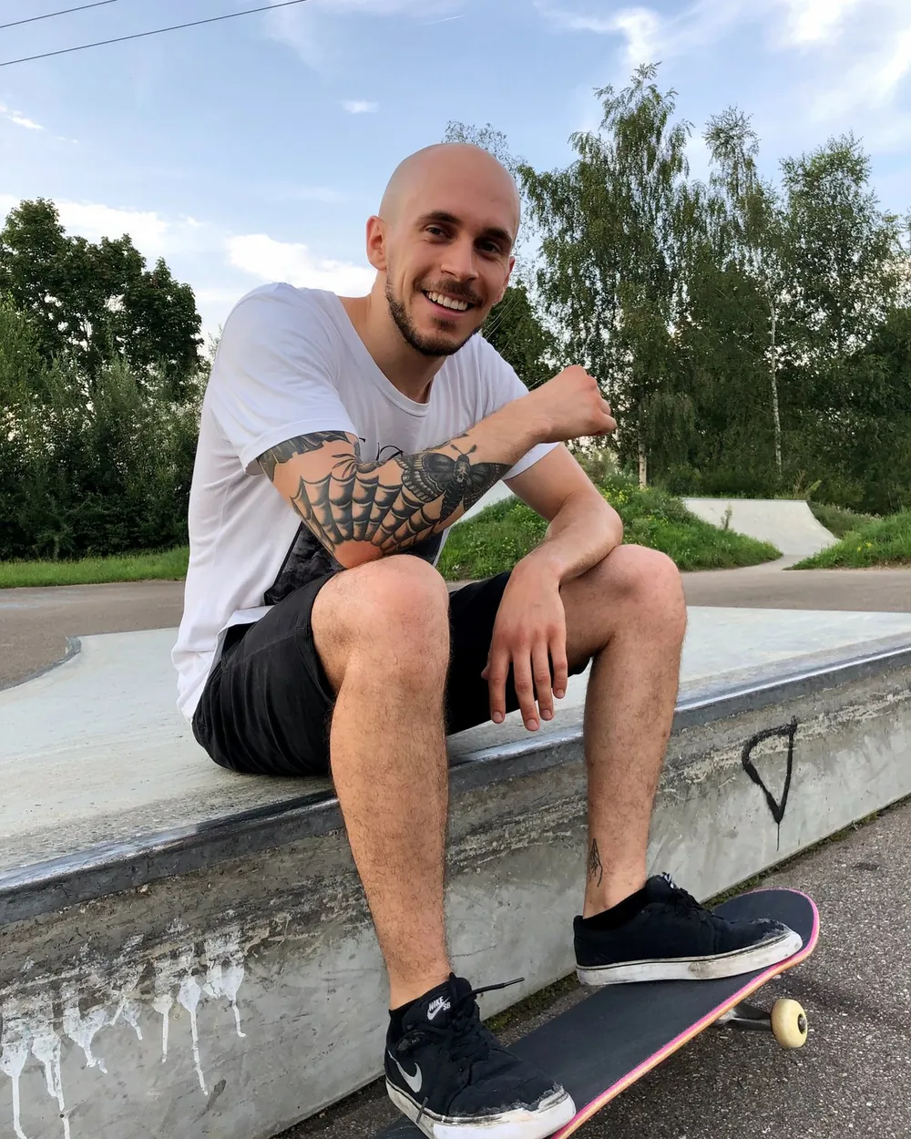 Lachender Skater mit seinem Board im Skatepark Burgau